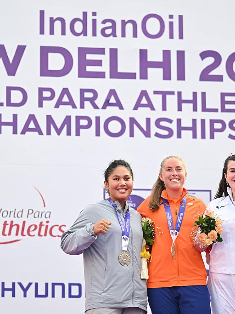 Three women showing their medals after a competition