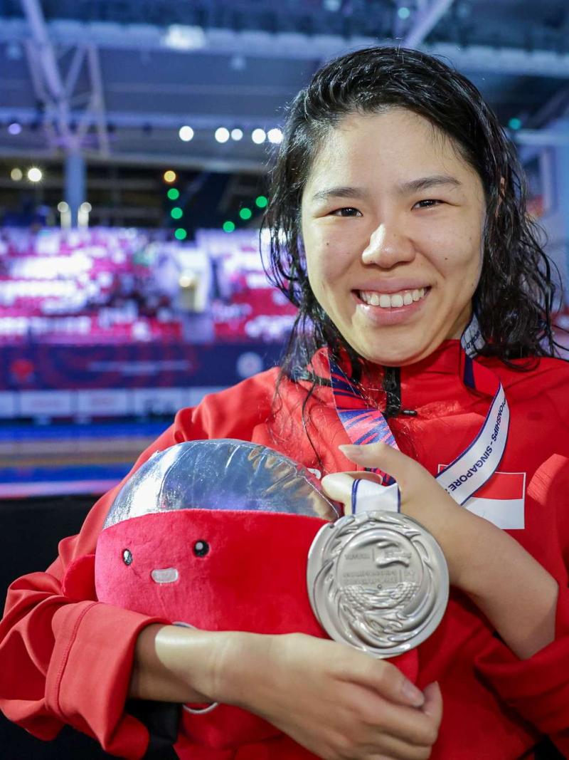 An athlete shows her medal 