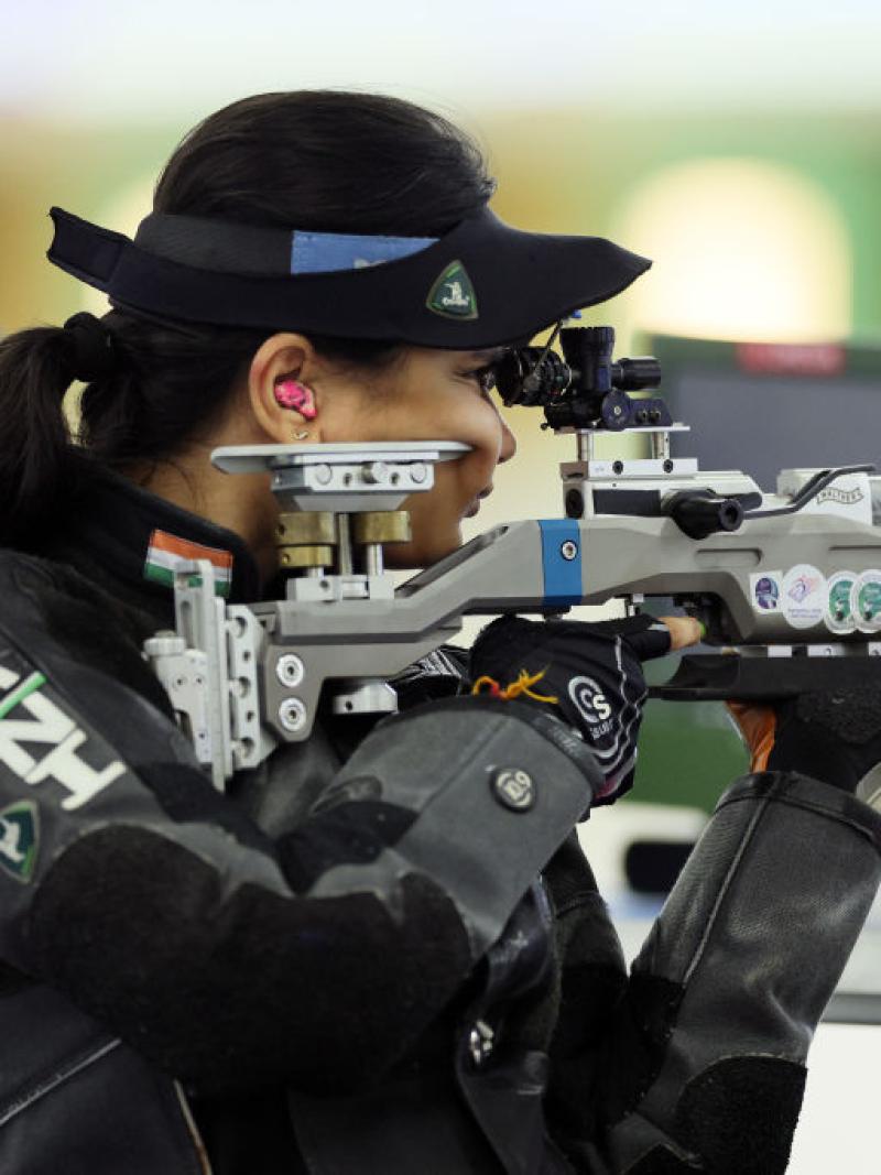 A female rifle shooter competing in a shooting range