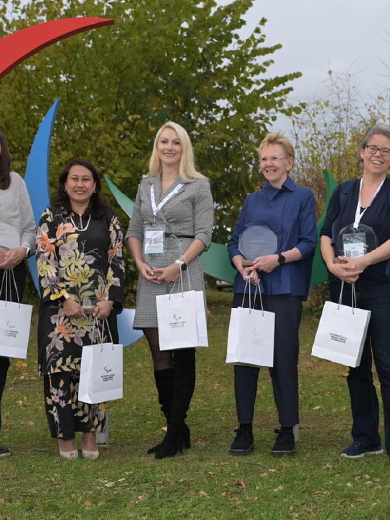 Recipients of the IPC 2025 Classification Recognition Award pose in front of the Agitos.