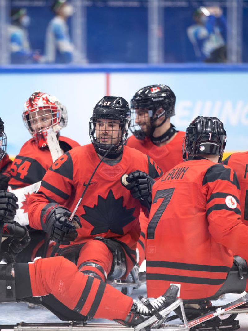 A group of Canadian Para ice hockey players gathering on the rink