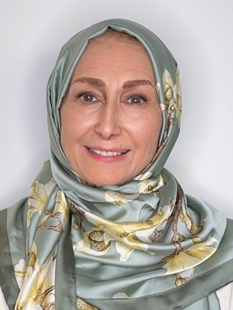 Sima Limouchi smiling in front of a white wall