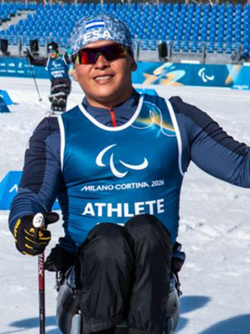 Two male sit-skiers are posing for a photograph on the snow