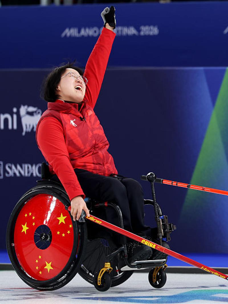 A wheelchair curling mixed doubles pair in action - the female player is celebrating