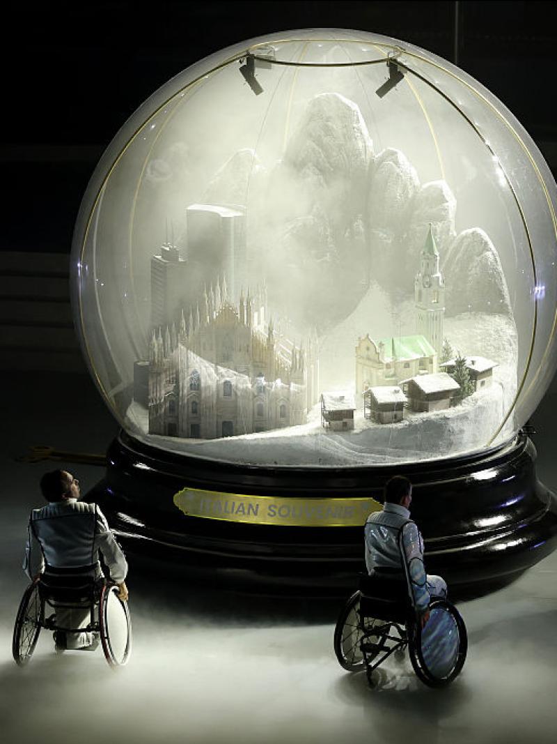Performers in wheelchairs surround a giant snow globe