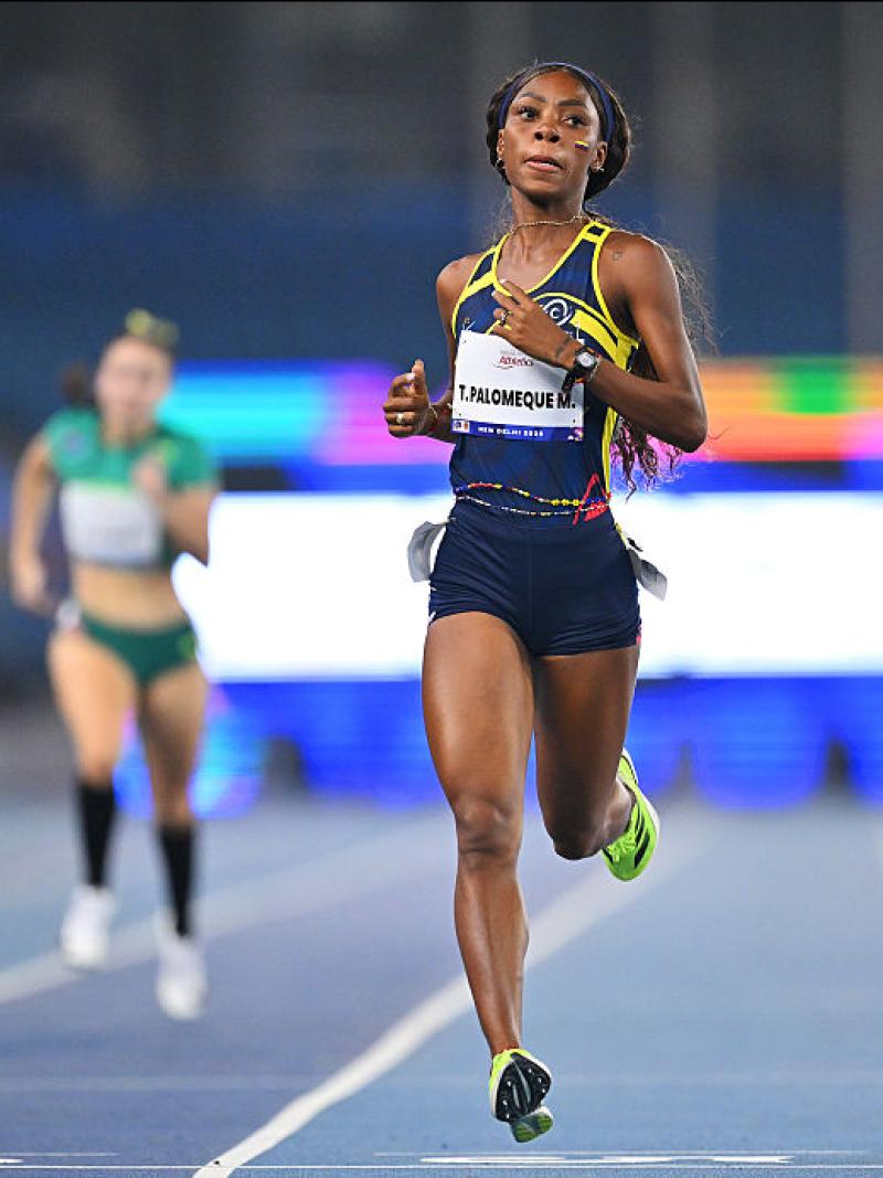 A female sprinter in a Para athletics event ahead of two other athletes