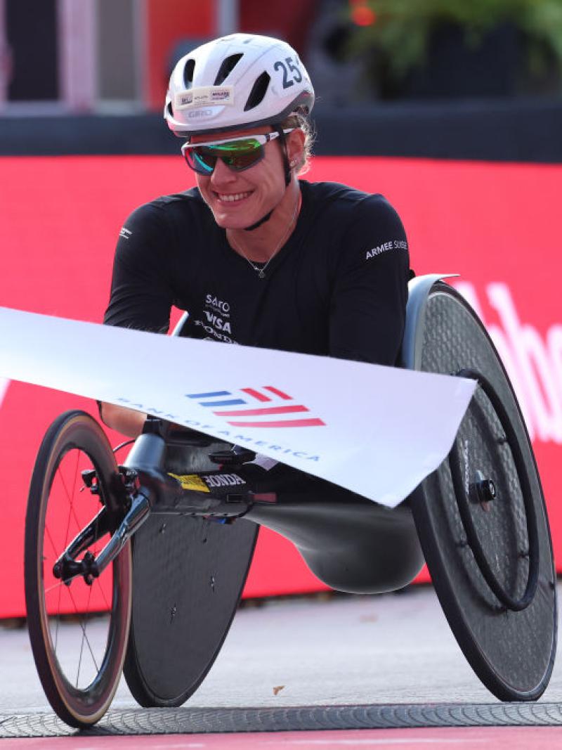 A female wheelchair racer crossing a marathon finish line