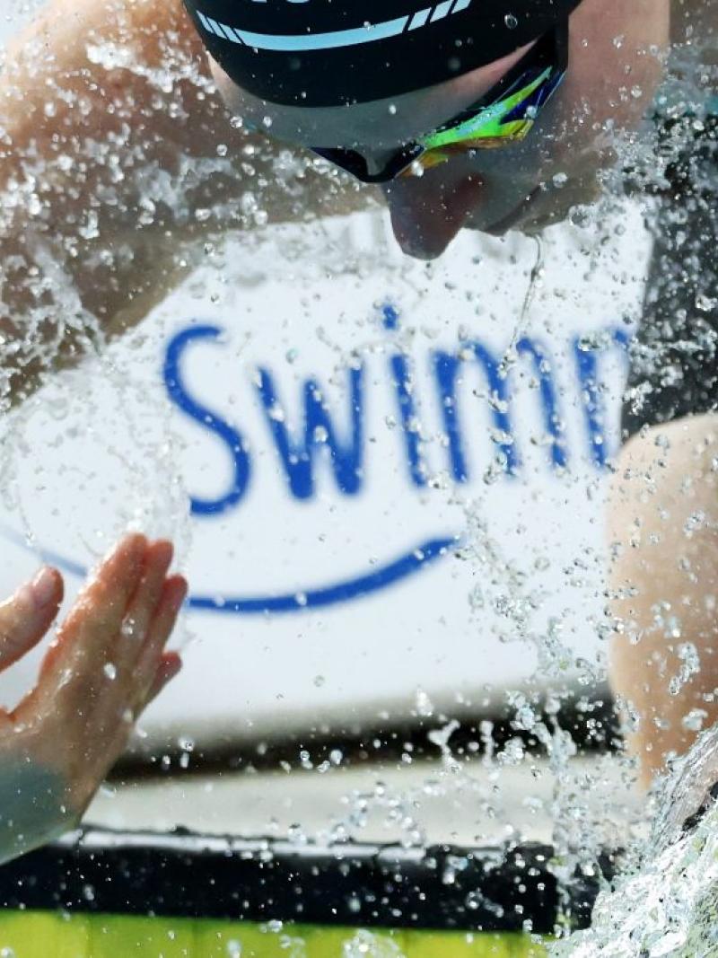 A female swimmer splashing water into herself