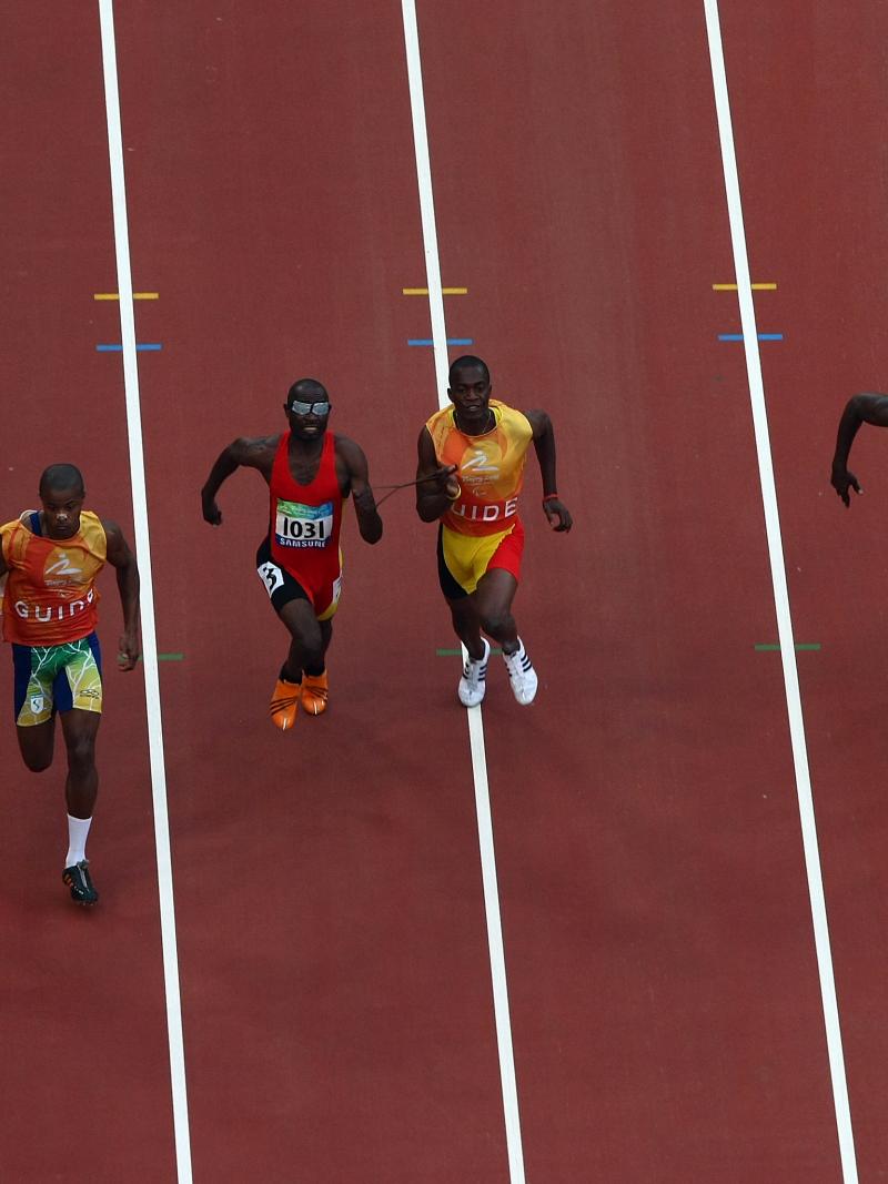 General view of athletes competing in the Men's 100m-T11