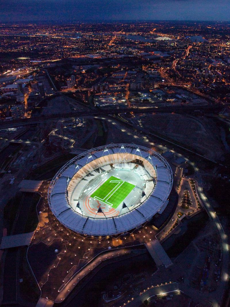 Aerial view of the London 2012 Olympic stadium with a "one" made of green lights in the center