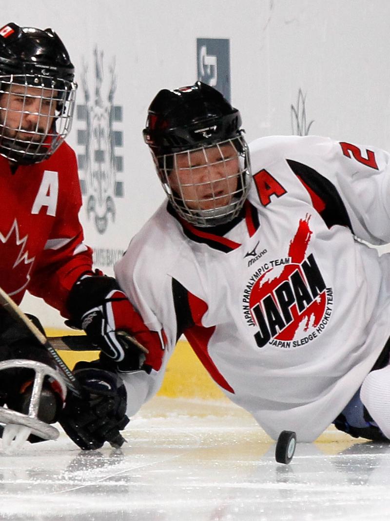 Satoru Sudo and Greg Westlake battle for the puck