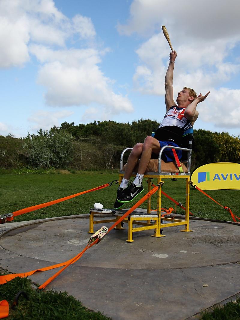 A picture of an athlete sit down throwing an object