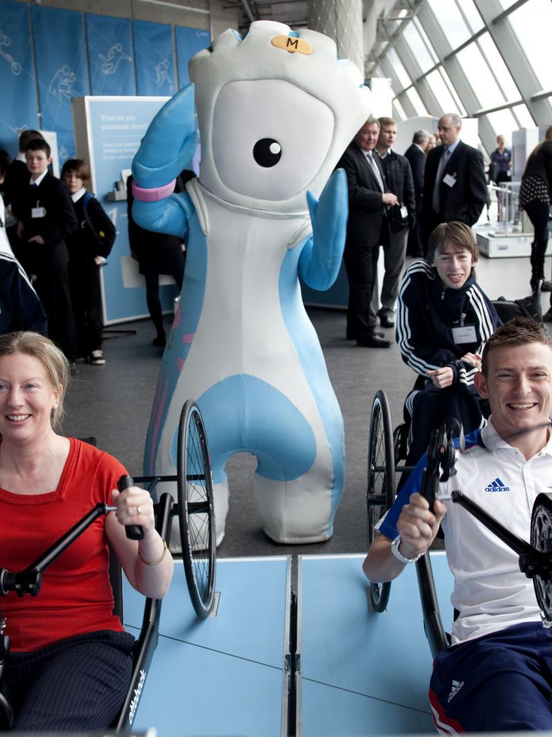 A picture of two person showing how to use a Handybike