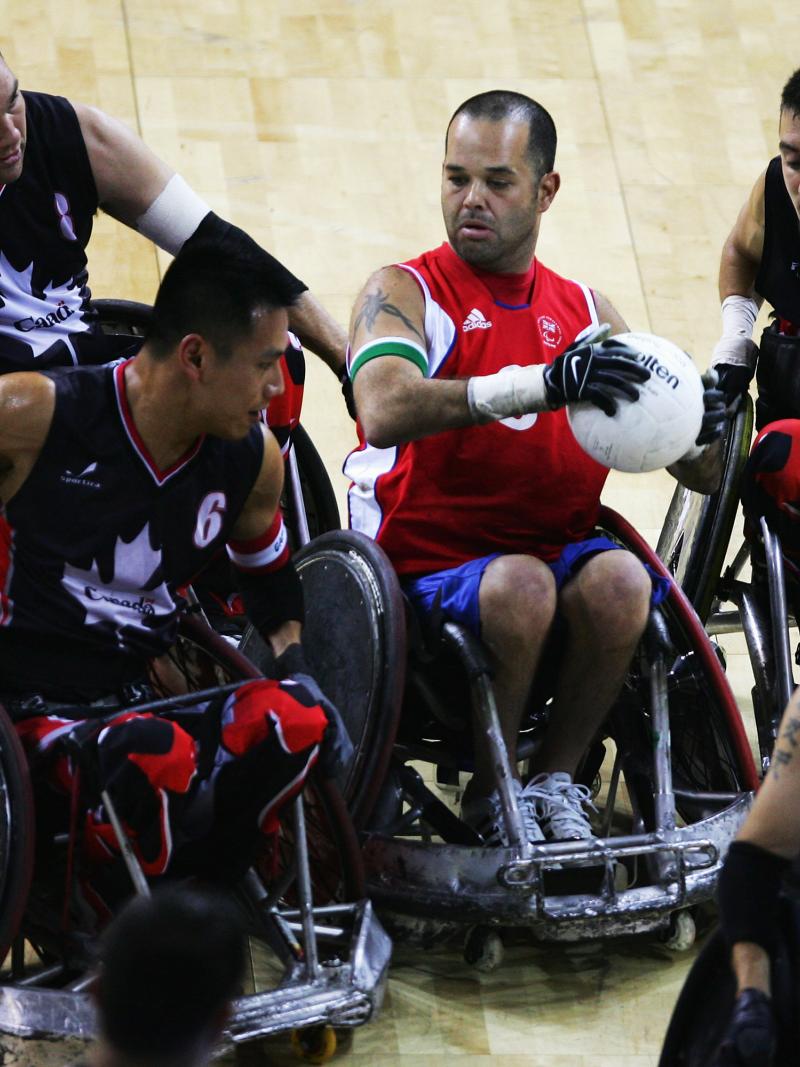 A picture of a person in a wheelchair trying to make a pass between four other person in a wheelchair.
