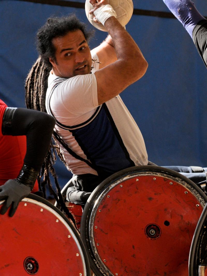 A picture of a man in a wheelchair trying to make a pass with a ball.