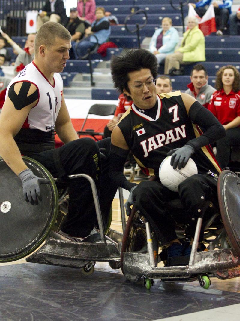 A picture of man in a wheelchair resisting to a choch with another wheelchair.