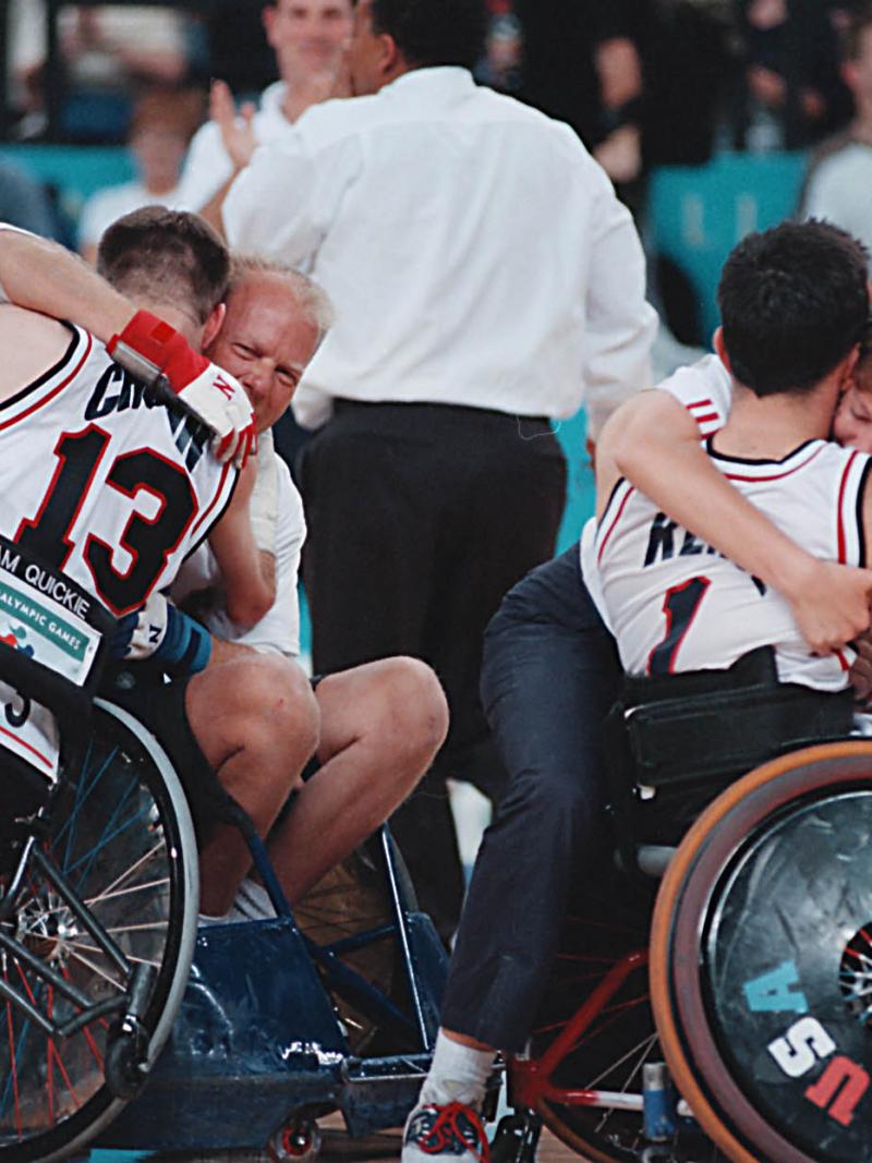 A picture of a man in a wheelchair and a girl celebrating a victory.