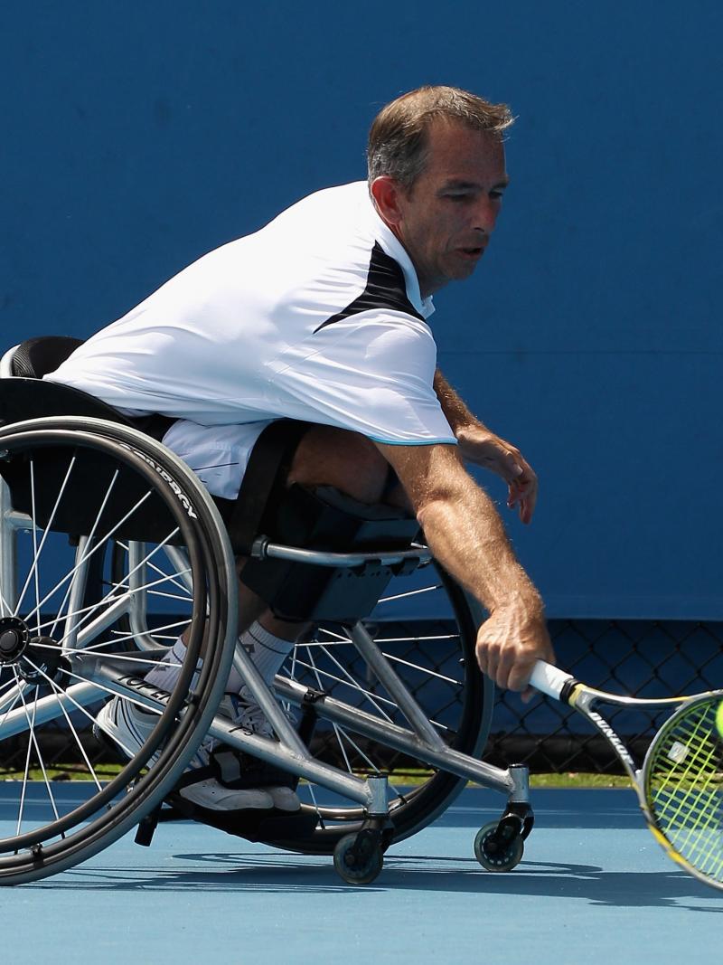 A picture of a man in a wheelchair playing tennis.