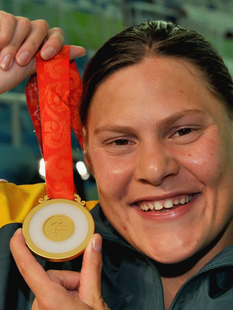 A picture of a girl showing a gold medal after her victory