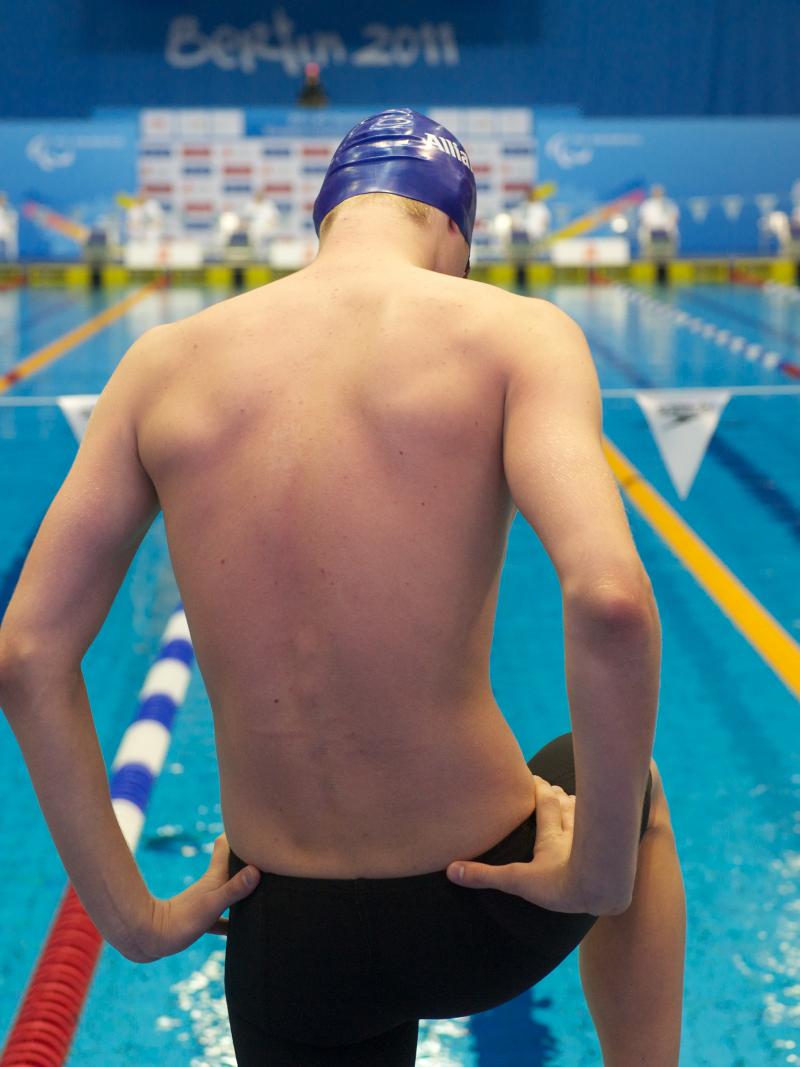 A picture of a man standing in front of a pool