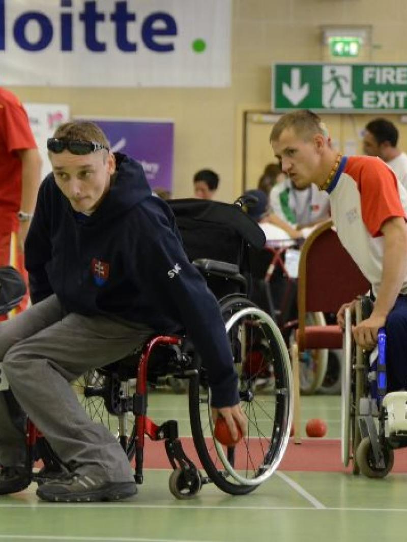 A picture of a man in a wheelchair throwing a small ball