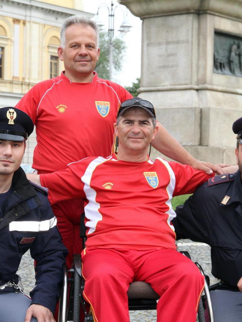A picture of a man in a wheelchair posing between 2 policemen