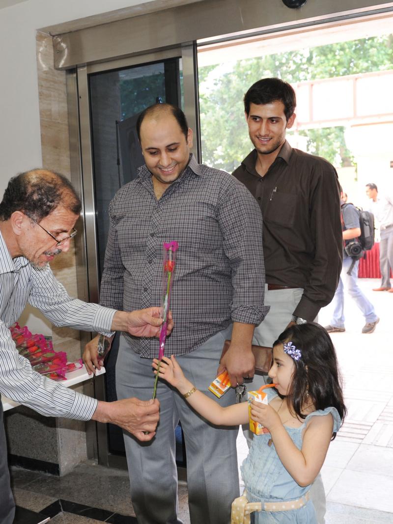 A picture of a man giving a flower to a young lady