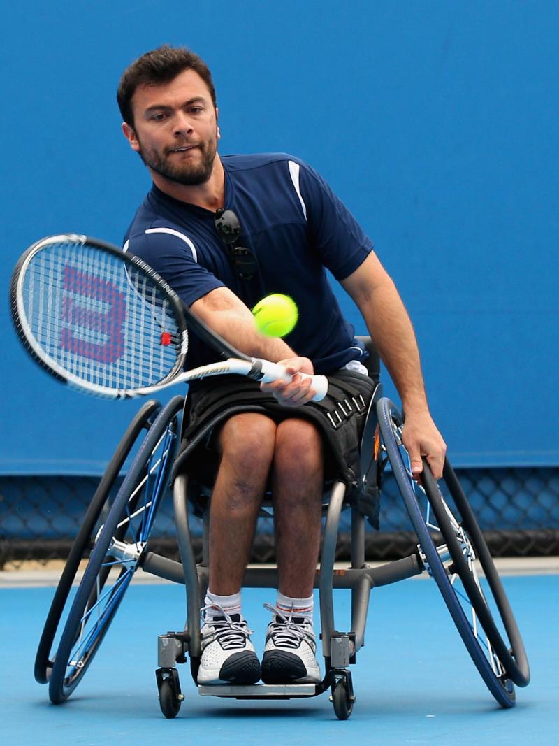 A picture of a man in a wheelchair playing tennis.