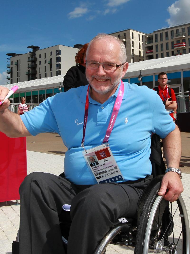 A picture of a man in a wheelchair signing a wall