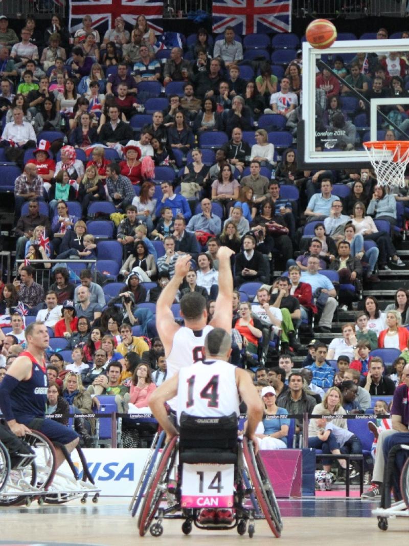 A picture of a man in a wheelchair shooting during a basketball match