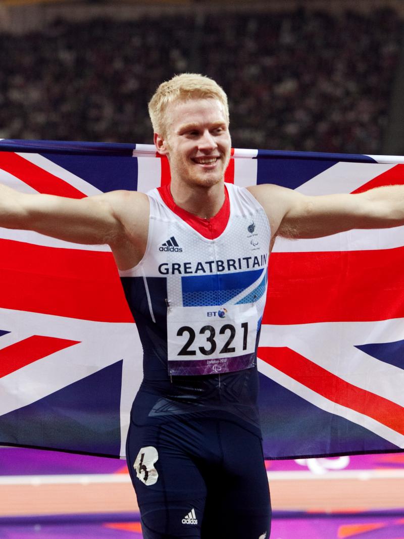 A picture of man celebrating his victory with a British Flag