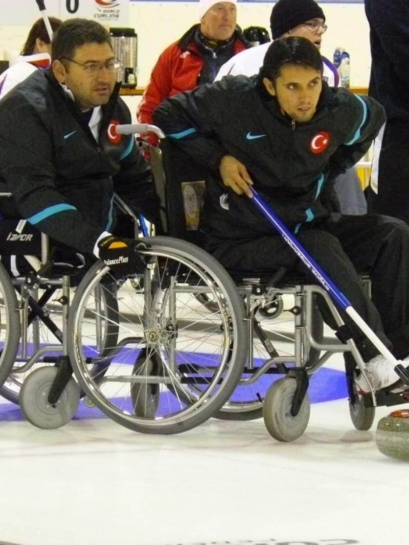 A picture of a man in wheelchair playing curling