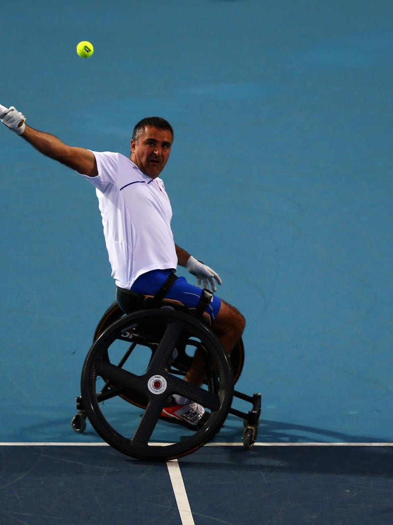 A picture of a man in a wheelchair playing tennis