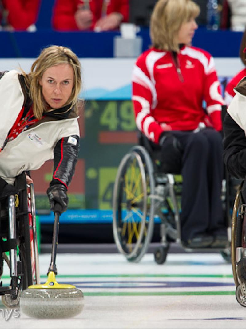 A picture of a man and a woman in a wheelchair playing curling