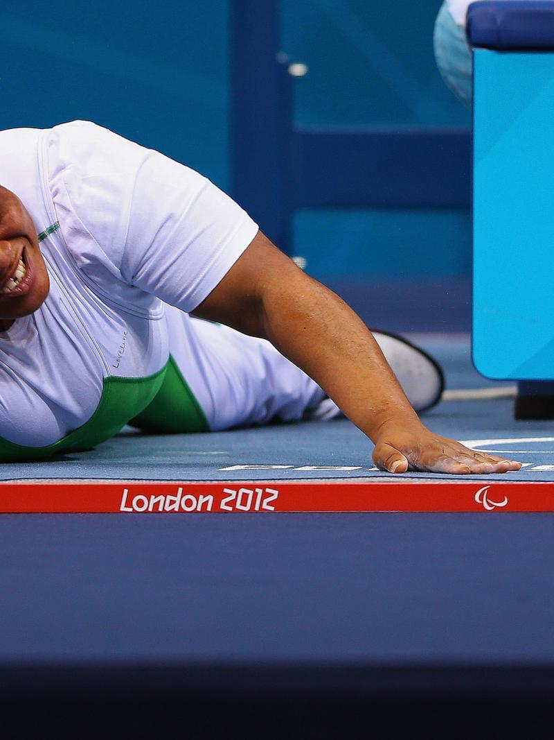 Loveline Obiji of Nigeria celebrates on the floor in the Women's -52 kg Powerlifting event.