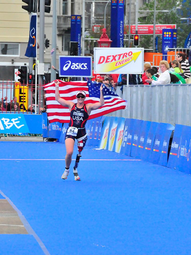 A picture of a woman with a prosthesis wearing an American flag to celebrate her victory