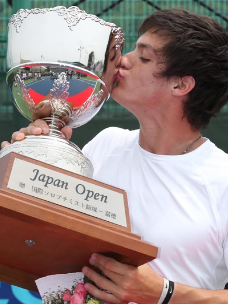 A picture of a man kissing his trophy after his victory