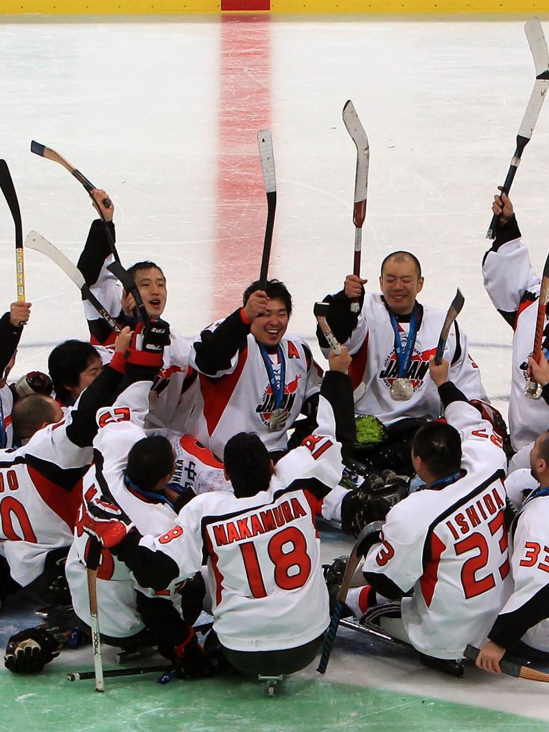 A picture of men playing sledge hockey celebrating their victory