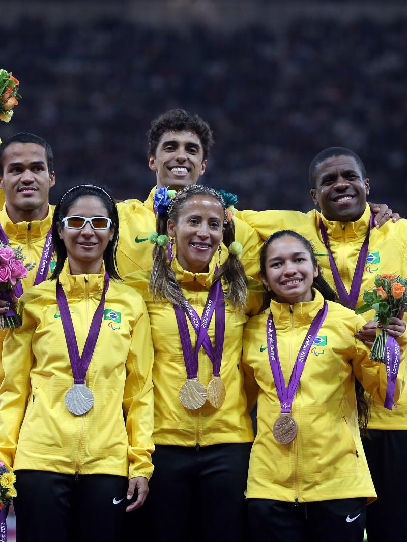 A picture of six person on a podium showing their medals