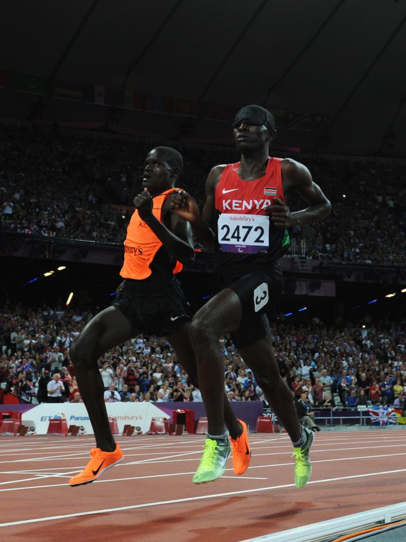 A picture of a blind man running with a guide