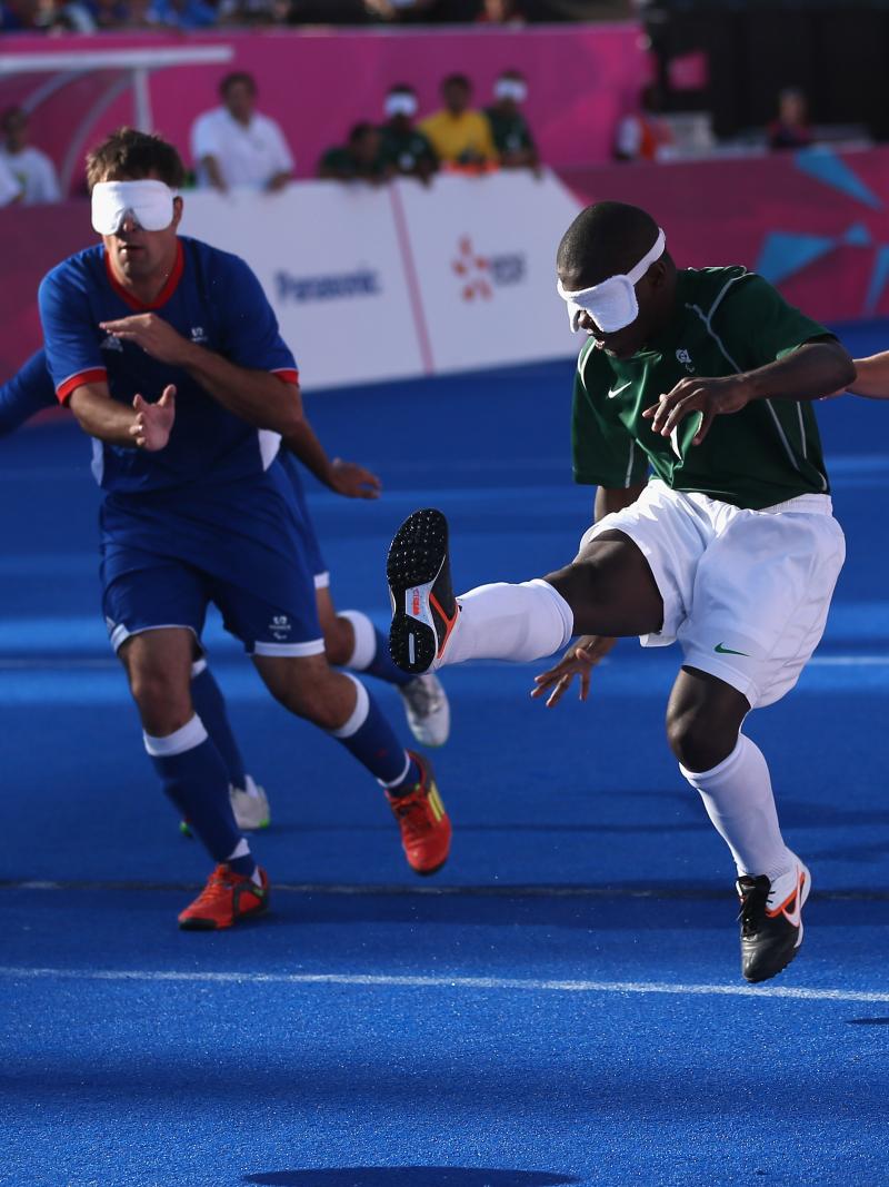 A picture of a blind person shooting the ball in a football match