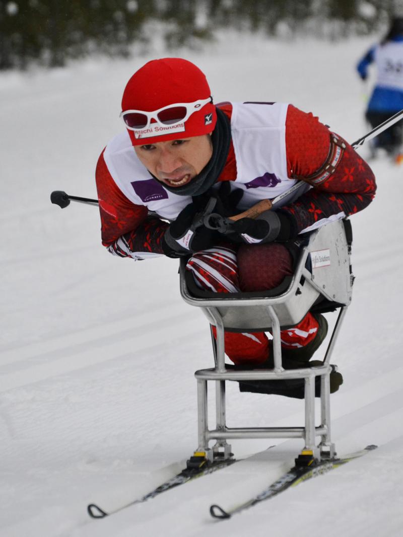 A picture of a man in a sledge skiing