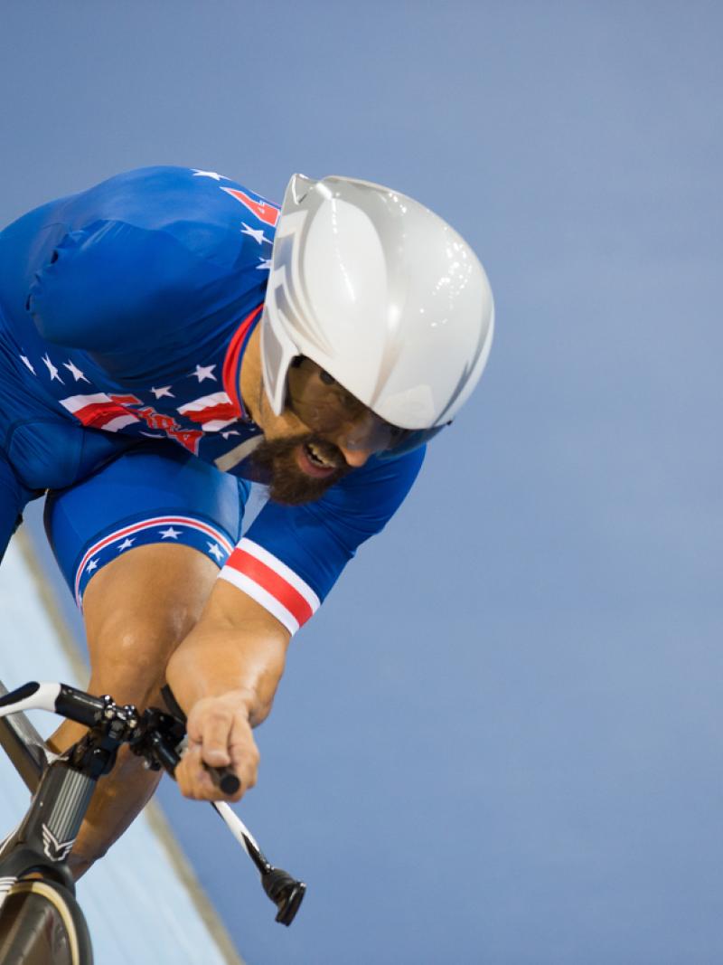 A picture of a man with one arm cycling during pursuit race.