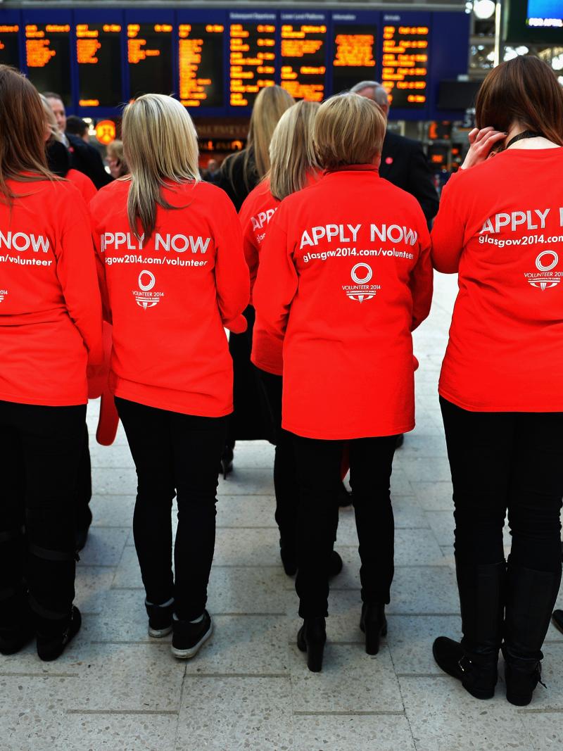 A picture of 5 persons wearing a Tshirt with "Apply Now" written on it.
