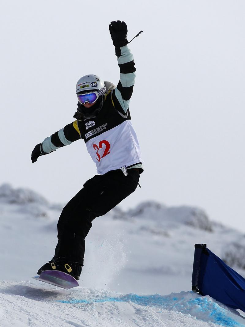 A picture of a woman jumping with a snowboard