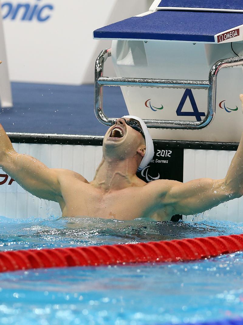 A picture of a man with his hands up in the pool