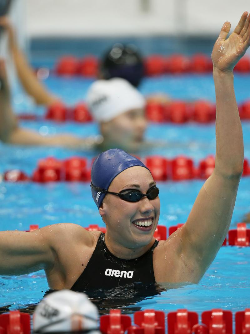 A picture of a woman in the pool with her hand up