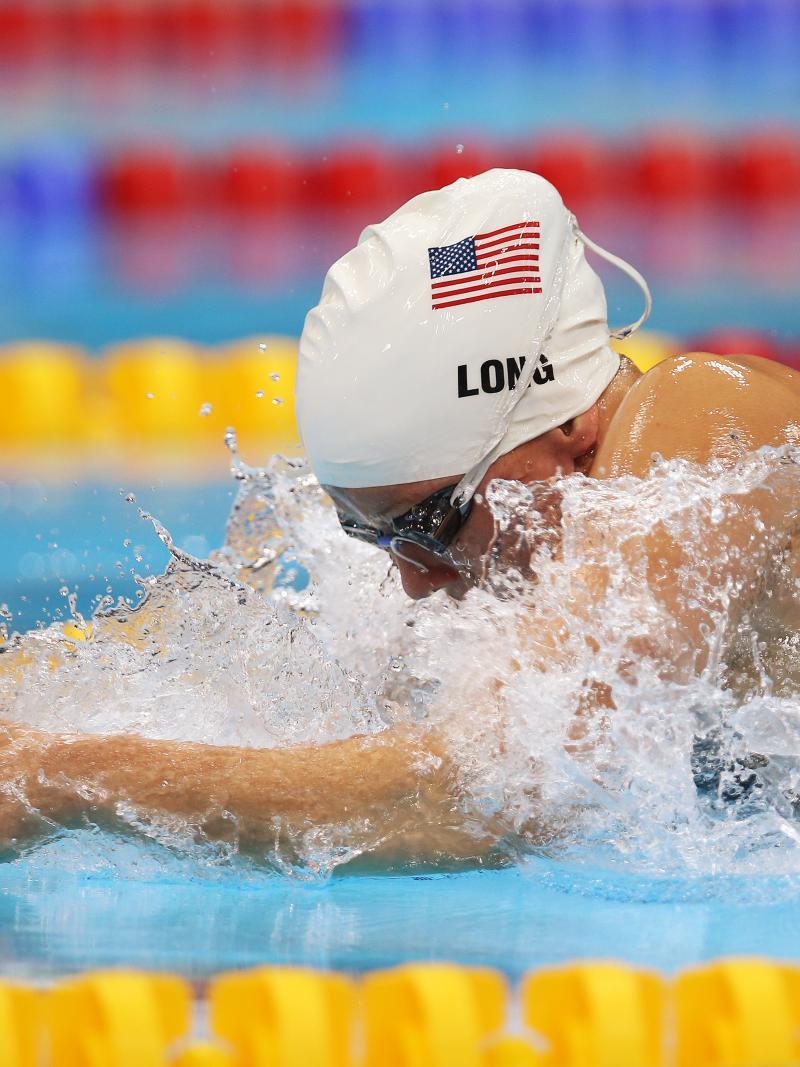 A picture of a woman in the pool with her head and hands above the surface