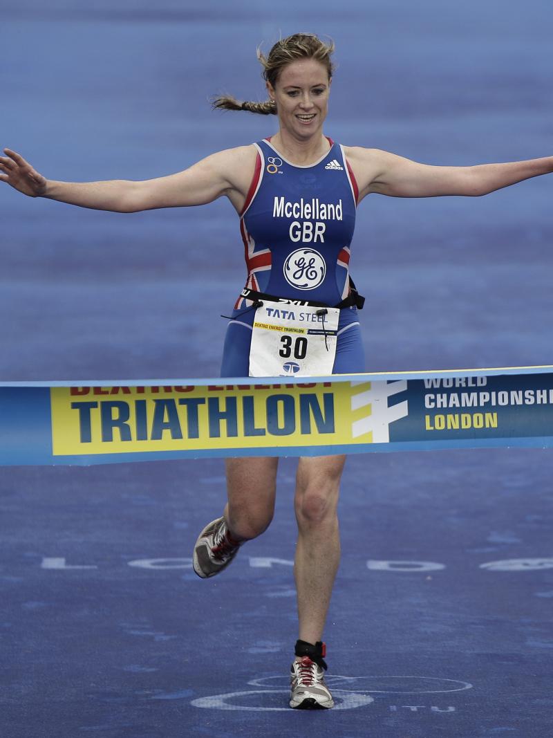 A picture of a woman crossing a finish line after a triathlon race