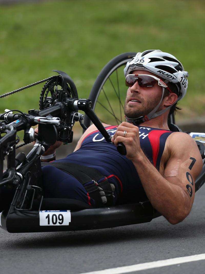 A picture of a man without leg cycling in a hand-cycle